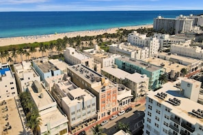 A coastal urban area with buildings, a beach, and palm trees. - Modern South Beach 1BR/1BA Beach 3 Min Away MLT (Miami Beach)