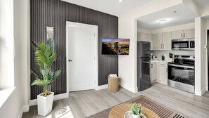 Una cocina moderna con electrodomésticos de acero inoxidable, un televisor de pantalla plana y vistas a la ciudad.