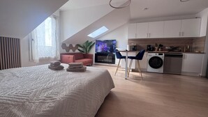 A modern loft apartment with a large bed, a dining area, a kitchen, and a living space. - ☀ El Cubanito | Studio 30 m² | Aéroport CDG – Paris ❤ (Villiers-le-Bel)