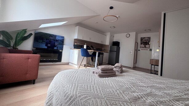 A modern apartment with a large bed, a TV, a kitchen, and a dining area. - ☀ El Cubanito | Studio 30 m² | Aéroport CDG – Paris ❤ (Villiers-le-Bel)