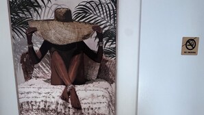 A wall with a framed artwork of a person holding a surfboard, a wooden coat rack, a no-smoking sign, a WiFi sign, and a doorbell. - ☀ El Cubanito | Studio 30 m² | Aéroport CDG – Paris ❤ (Villiers-le-Bel)