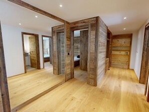 A room with wooden panel walls, a wooden floor, and a large mirror. - Alphubel Peak & Unlimited by Interhome (Saas-Fee)