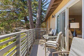 A balcony with a table and chairs, overlooking a forested area. - 4075 Scotty's Treehouse, Forest Views, Dog Welcome (Carmel-by-the-Sea)