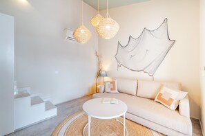 Ein modernes Wohnzimmer mit einer Couch, einem runden Couchtisch und einer Treppe.