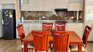 A compact kitchen with a dining table and chairs, a refrigerator, and a stove. - Apartment with privileged location in Paipa (Paipa)