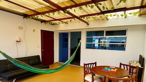 A room with a hammock, a dining table with chairs, a sofa, and a window with a view. - Apartment with privileged location in Paipa (Paipa)