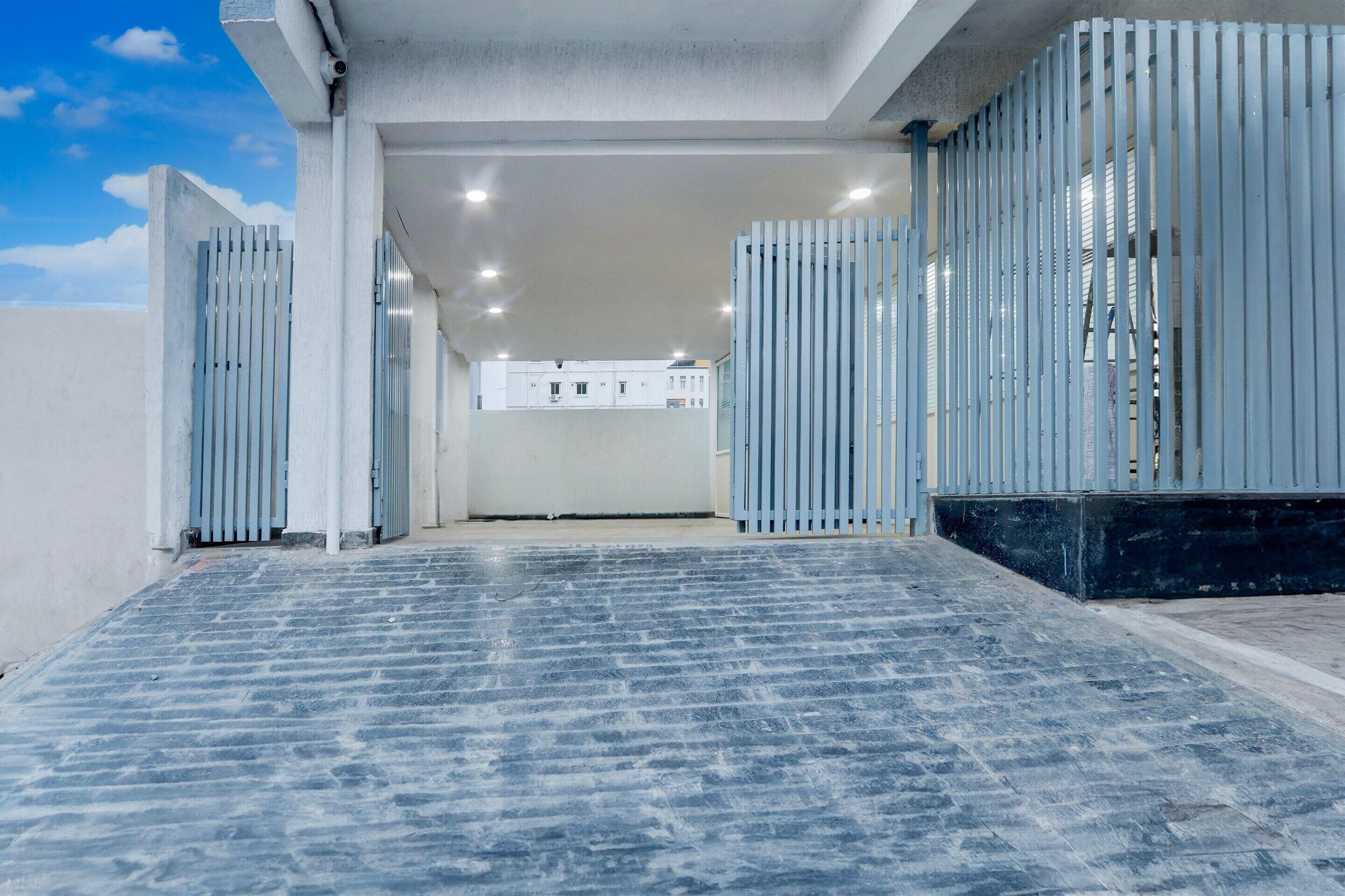 A modern building with a flat roof, large windows, and a paved entrance area.