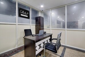 Un espacio de oficina moderno con un escritorio de madera oscura, una computadora portátil, una silla negra y un letrero que dice 'Collection Company-Serviced'.