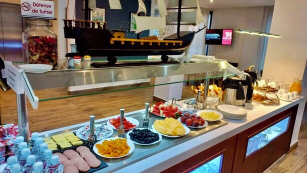 Un buffet proposant divers plats, une décoration sur le thème des bateaux et un panneau indiquant qu'il est interdit de fumer.