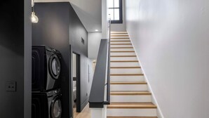 Ein modernes Interieur mit Treppe, Waschmaschine und Fenster.