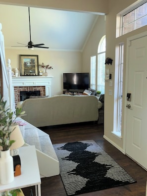 A bedroom with a bed, a TV, a fireplace, and a door. - 2-Story Central Edmond Home - 4 bed 2.5 bath (Edmond)