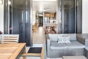A modern living area with a sofa, a dining table, and a kitchen in the background. - Oceanfront Sapphire – Water Views, Sleeps 6, Beach (St. Thomas)