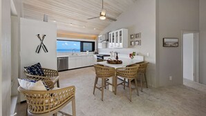 Eine moderne Küche mit Blick, Korbmöbeln und einem Deckenventilator.