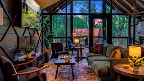A modern interior with a large window, a sofa, a coffee table, and a chair. - Indoor Private Pool, Sleeps 12, In Gatlinburg (Gatlinburg)