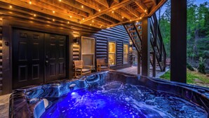 A wooden cabin with a hot tub, wooden deck, and a staircase leading to a loft. - Indoor Private Pool, Sleeps 12, In Gatlinburg (Gatlinburg)