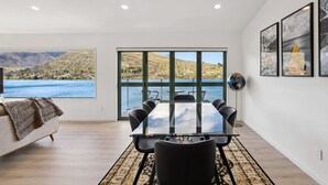 Una habitación moderna con un ventanal grande, una mesa de comedor y un globo terráqueo en la pared.