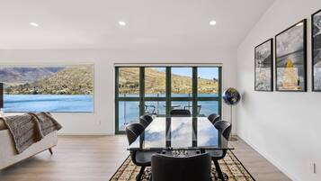 A modern room with a large window, a dining table, and a globe on the wall.