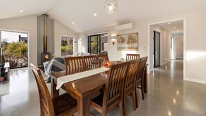 Un comedor amplio con una mesa y sillas de madera, una chimenea y vistas al exterior.