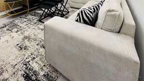 Ein modernes Wohnzimmer mit einer Couch, einem Fernseher und einer Chandeliebre.