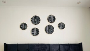 Ein Bett mit schwarzem Kopfteil, weißen und blauen Kissen und einer gelben Bettdecke.