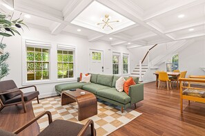 A spacious living room with a sectional sofa, a coffee table, and a dining area with chairs. - Sylvans Escape - Pool, Hot Tub, Games, Sleeps 12, 10mins from World Cup Stadium (Atlanta)