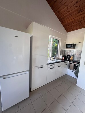 Eine moderne Küche mit einem weißen Kühlschrank, einer Mikrowelle und einem Herd.
