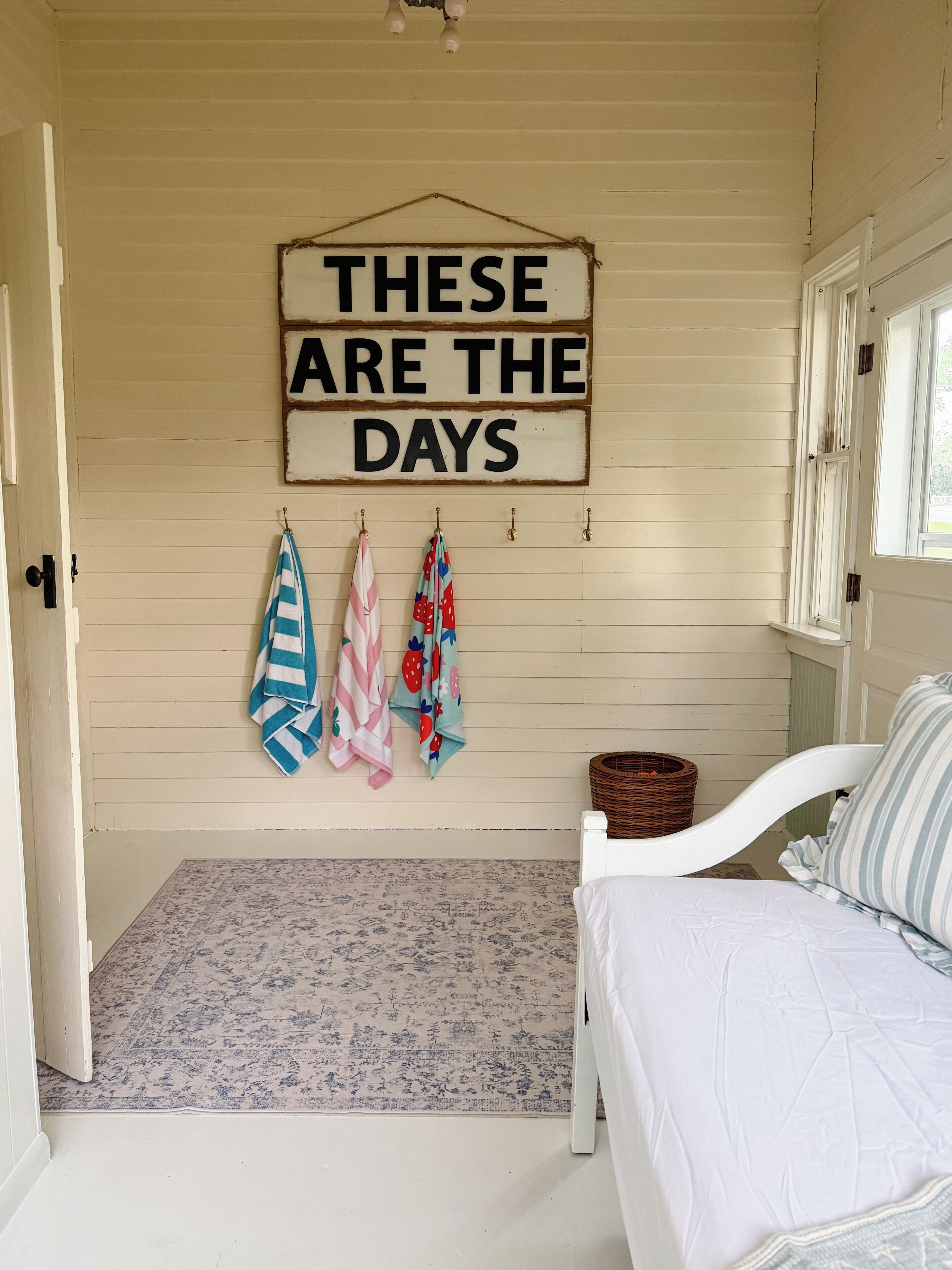 Une chambre à coucher avec un lit, une enseigne suspendue et un tapis à motifs.