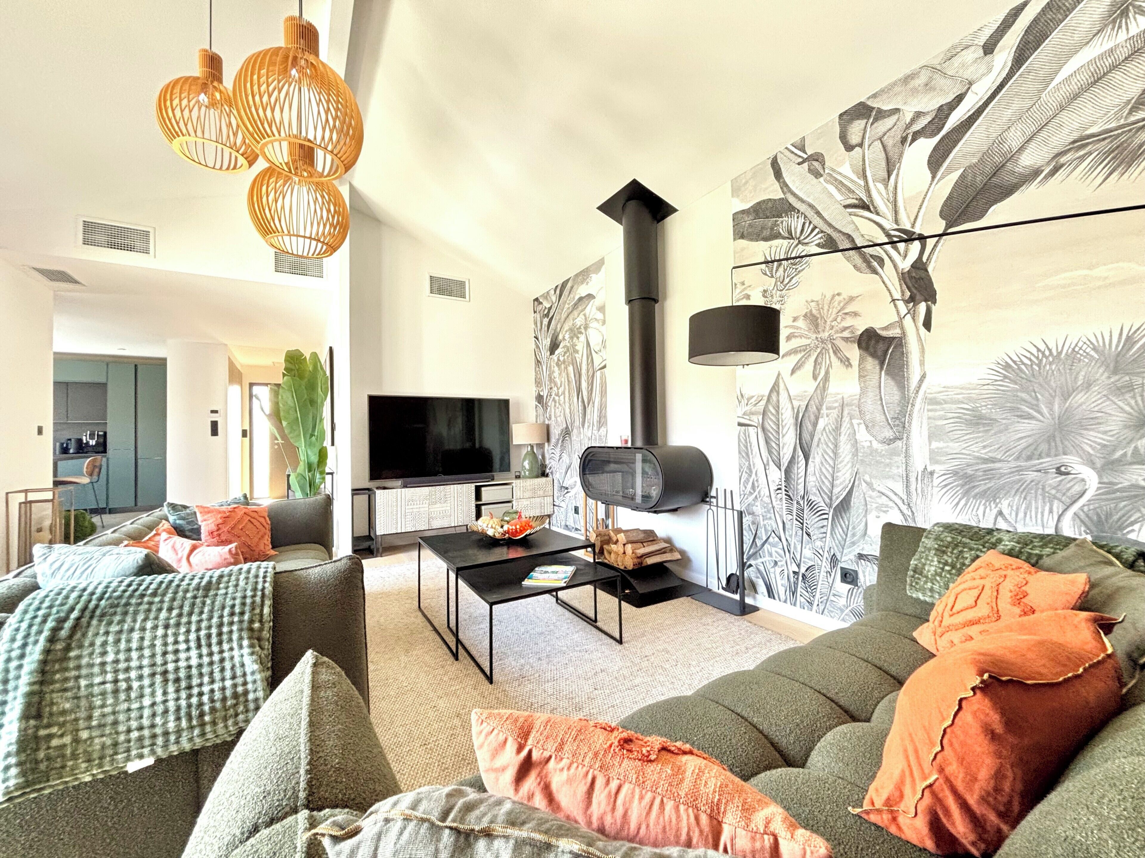 A modern living room with a sofa, coffee table, and a large wall mural.