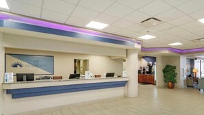 A reception area with a counter, computers, and a framed logo on the wall. - Oceanfront Apartment  Daytona Beach for rent (Daytona Beach)