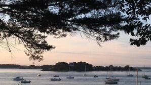 A marina with various boats docked, surrounded by trees and a distant shoreline. - Tides & Trails - SAINT GILDAS DE RHUYS (SAINT GILDAS DE RHUYS)