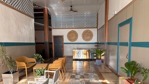 A spacious indoor area with a patterned floor, wicker furniture, and potted plants. - Vicina Maris Beach Lodge (Maria Chiquita)