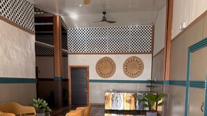 A spacious indoor area with a patterned floor, wooden furniture, and decorative wall panels. - Vicina Maris Beach Lodge (Maria Chiquita)