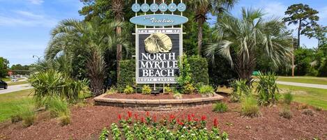 Schild für North Myrtle Beach in South Carolina mit Palmen im Hintergrund.