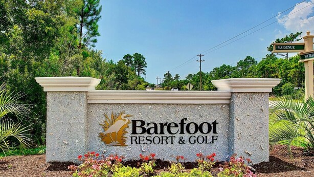 Une enseigne pour le complexe hôtelier et golfique Barefoot, avec un logo représentant un oiseau et le nom de l’établissement.