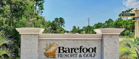 A sign for Barefoot Resort & Golf with a logo of a bird and the name.