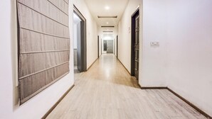 En lång, smal hall med trägolv och vita väggar.