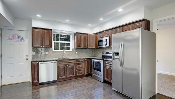 A modern kitchen with wooden cabinets, stainless steel appliances, and a dishwasher. - Spacious 4-bedroom house with AC in brilliant Annapolis (Annapolis)