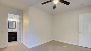 A room with a ceiling fan, a door, and a corner with a dark-colored cabinet and a mirror. - Spacious 4-bedroom house with AC in brilliant Annapolis (Annapolis)