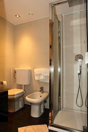 A modern bathroom with a glass-enclosed shower, a toilet, and a bidet. - Hotel San Carlo (Lignano Sabbiadoro)