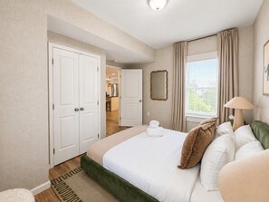 A hotel room with a bed, a nightstand, a lamp, a mirror, and a view of the outside. - Free Parking | Walk to Yale & Frank Pepe’s (New Haven)