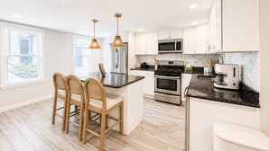 A modern kitchen with a central island, stainless steel appliances, and pendant lighting. - Free Parking | Walk to Yale & Frank Pepe’s (New Haven)