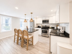 A modern kitchen with a central island, stainless steel appliances, and pendant lighting. - Free Parking | Walk to Yale & Frank Pepe’s (New Haven)