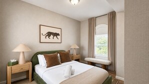 A hotel room with a bed, two nightstands, a bench, a window with curtains, and a wall-mounted picture. - Free Parking | Walk to Yale & Frank Pepe’s (New Haven)