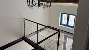 En trappa med ett metallräcke, en kristallkrona och ett fönster med utsikt.