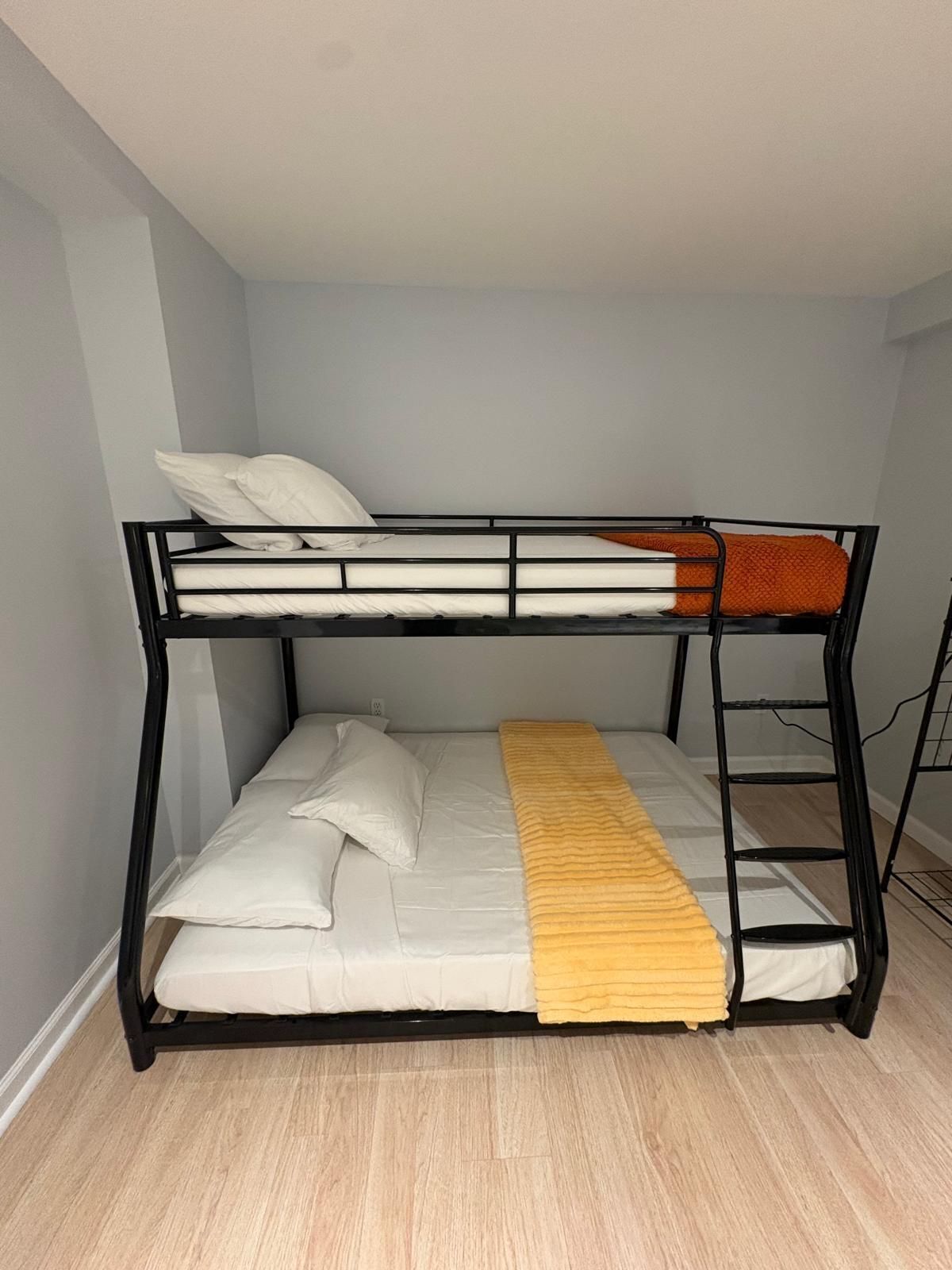 A bunk bed with a ladder, white pillows, and a yellow blanket.