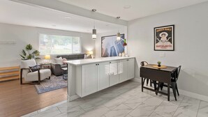 A modern living room with a sofa, a dining table, and a kitchen island. - Private Upper Unit Home, Pet Friendly, Min to DT (Arvada)