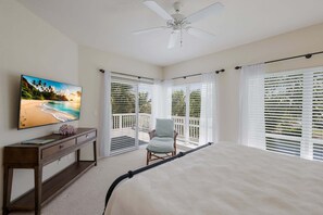 A bedroom with a bed, a TV on the wall, a chair, and a ceiling fan. - Boca Bay Kentia - 3 bed / 3 bath - 30 night minimum - Summer/Fall Pricing! (Boca Grande)