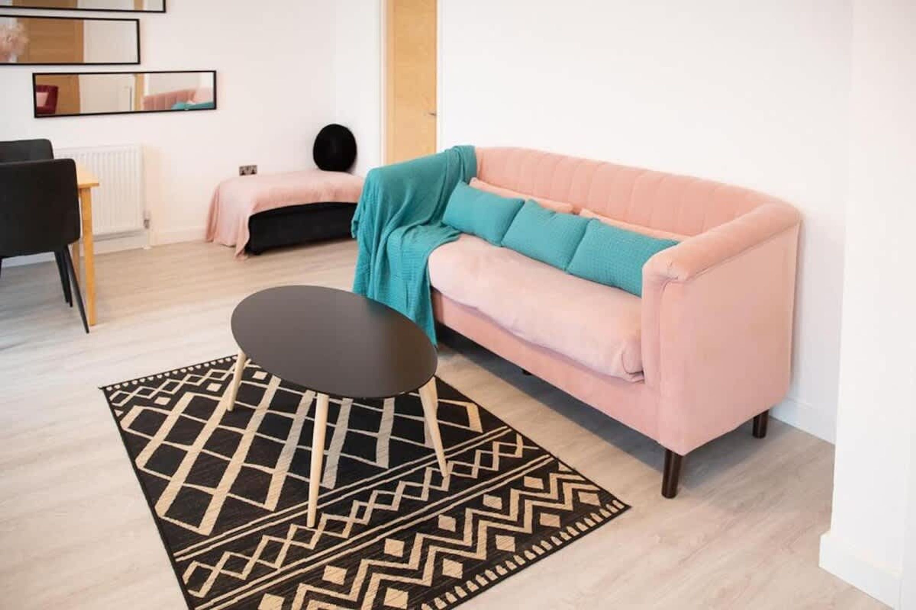 Una sala de estar moderna con un sofá, una mesa de centro y una alfombra estampada.