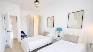A hotel room with two beds, a desk, a chair, and artwork on the walls. - 2 BR Sofabed 11 Mins to Gallops Parking Garden (Newmarket)