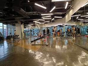 A gym with various exercise equipment, large mirrors, and a polished floor. - Room-lerfo Staycation!!!! (Mandaluyong)